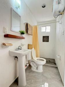 ein weißes Badezimmer mit Toilette und Waschbecken in der Unterkunft Monet Hotel Motul in Motul de Felipe Carrillo Puerto + 24 Fotos