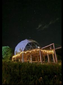 um observatório com cúpula em um campo à noite em Glamping Store em Guatavita