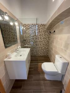 een badkamer met een witte wastafel en een toilet bij Casa do largo in Olhão +6 foto's