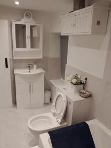 een witte badkamer met een toilet en een wastafel bij Penzer Cottage in Mousehole +14 foto's
