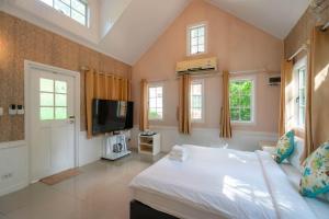a bedroom with a bed and a tv and windows at Puprai Tarnnarm Resort in Thong Pha Phum
