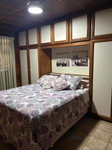 ein Schlafzimmer mit einem Bett mit einer lila Decke in der Unterkunft Angra dos Reis - Píer 600 casa 4 in Angra dos Reis + 15 Fotos