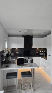 een keuken met witte kasten en een tafel en stoelen bij Modern 1 bedroom riverside apartment in Ayr