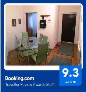 a dining room with a table and green chairs at Niš Apartman in Niš