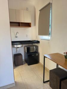 a small kitchen with a stove and a microwave at Studio Park e Mar a 600m do Beto Carrero in Penha