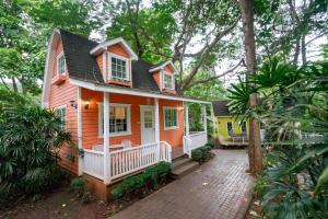 a small orange house with a white porch at Puprai Tarnnarm Resort in Thong Pha Phum