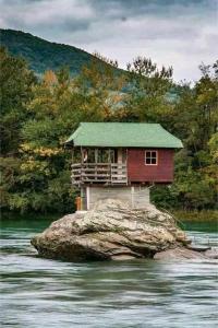 een klein huisje op een rots in het water bij Apartman,,Petko,, in Bajina Bašta