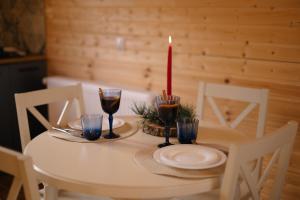 a white table with a candle and glasses on it at Kamara in Sioni