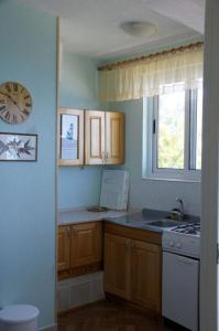 een keuken met houten kasten en een klok aan de muur bij Apartments Sonja in Živogošće