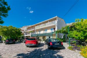 une rue avec des voitures garées devant un bâtiment dans l'établissement Apartments Boro, à Dugi Rat