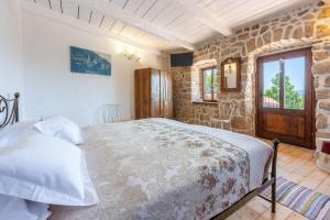 a bedroom with a bed and a stone wall at Villa Natalia in Grižane +54 photos