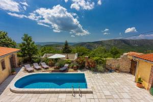 a swimming pool in a yard with a patio with chairs at Villa Natalia in Grižane