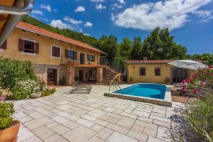 an outdoor patio with a swimming pool and a house at Villa Natalia in Grižane