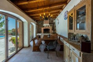a kitchen with a wooden table and a fireplace at Villa Natalia in Grižane