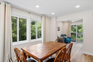 ein Esszimmer mit Tisch und Stühlen und Fenstern in der Unterkunft Ocean Glen 8 Sea Clearly in Salter Path