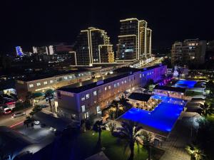a building with a pool in front of a city at night at Caesar Resort Lux Studio Apt in Trikomo