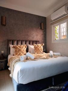 een slaapkamer met een groot bed met witte lakens bij Riad Darnooz Marrakech in Marrakesh