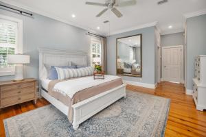 ein Schlafzimmer mit einem großen Bett und einem Spiegel in der Unterkunft 4323 Ninth Street in Saint Simons Island + 51 Fotos