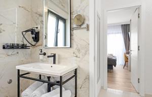 een witte badkamer met een wastafel en een spiegel bij Quercus Vodice in Vodice