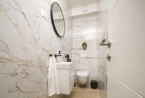 een witte badkamer met een wastafel en een spiegel bij Quercus Vodice in Vodice +36 foto's