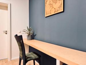 een kamer met een houten bureau en een stoel bij Hiddenhausen Premium Apartment in Hiddenhausen