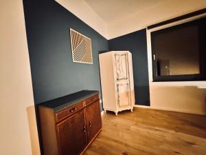 een kamer met een koelkast en een houten vloer bij Hiddenhausen Premium Apartment in Hiddenhausen +67 foto's