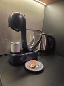 a coffee maker with a cup and a donut on a plate at Tara Breeze Apartments in Kolašin +23 photos