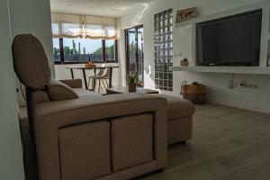 ein Wohnzimmer mit Sofa und Flachbildfernseher in der Unterkunft Villa Cactus - Large Private Plot - Heated Pool & BBQ - Luxury Vacation in Playa Blanca