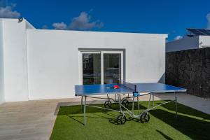 eine blaue Tischtennisplatte auf einer Terrasse in der Unterkunft Villa Cactus - Large Private Plot - Heated Pool & BBQ - Luxury Vacation in Playa Blanca