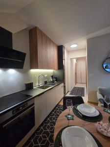 a kitchen with a table and a sink in a room at Tara Breeze Apartments in Kolašin
