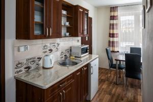 uma cozinha com um lavatório e uma mesa com cadeiras em Magdalenka 5 min pieszo od Kotelnicy em Białka Tatrzanska mais 33 fotografias