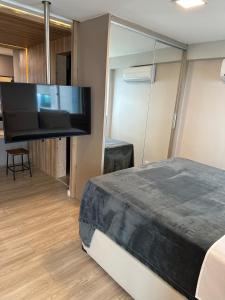 a bedroom with a bed with a large flat screen tv at 2703 Flat Beira Mar Av Boa Viagem com Cozinha in Recife +26 photos