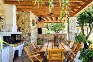 un patio esterno con tavolo e sedie in legno di Villa Claire 10-Acre Private Estate with Pool near Corfu Old Town a Gastouri