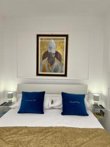 a bedroom with a bed with a painting on the wall at Casa Del Duca in Salerno