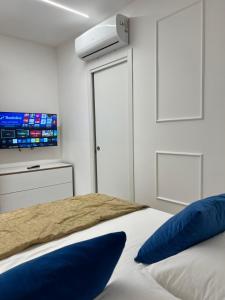 a bedroom with a bed with a tv on the wall at Casa Del Duca in Salerno