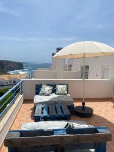 2 letti su un balcone con ombrellone di Pina Hideaway with a sea view rooftop terrace a Bicas