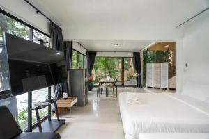 Puprai Tarnnarm Resort في ثونغ فا فوم: غرفة نوم بسرير أبيض ونافذة كبيرة