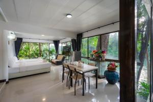 Puprai Tarnnarm Resort في ثونغ فا فوم: غرفة معيشة مع طاولة وكراسي وأريكة