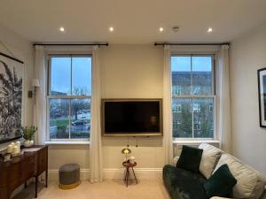 a living room with a couch and a flat screen tv at Station Bridge Collection - Flat 4 in Harrogate