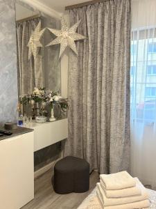 a bathroom with a vanity with a mirror and a stool at Sara Suite in Sibiu