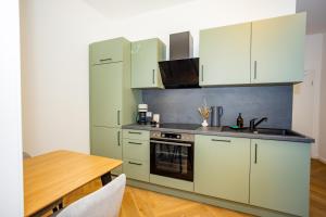 een keuken met witte kasten en een houten tafel bij Fidelios Altstadt Appartements in Weiden +24 foto's