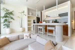 een woonkamer met een bank en een keuken bij Sore Pererenan Residence Unit 3 in Canggu