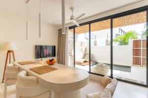 een woonkamer met een tafel en stoelen en een televisie bij Sore Pererenan Residence Unit 3 in Canggu
