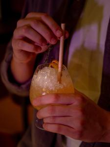 a person holding a drink in a glass at Hotel Indigo Berlin - East Side Gallery in Berlin