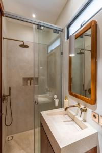 een badkamer met douche, wastafel en spiegel bij Sore Pererenan Residence Unit 3 in Canggu +20 foto's