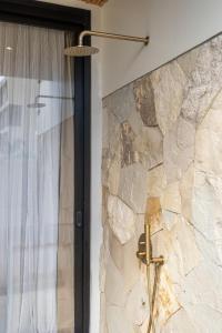 een stenen muur in een badkamer met een douche bij Sore Pererenan Residence Unit 3 in Canggu