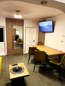 una stanza con tavolo e televisione sul muro di Casa Lăpușană a Lăpuş