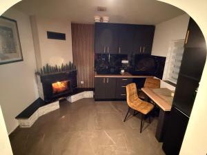 una cucina con camino, tavolo e sedie di Casa Lăpușană a Lăpuş Altre 14 foto