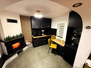 una cucina con camino, tavolo e sedie di Casa Lăpușană a Lăpuş