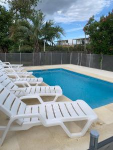 uma fileira de espreguiçadeiras ao lado de uma piscina em Pucara del Este em Punta del Este